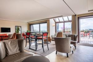 a room with chairs and a table and windows at Warwick Brussels Grand-Place in Brussels