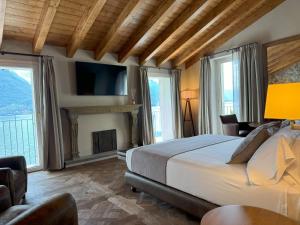 a bedroom with a bed and a fireplace and windows at Al Molo 5 - Lake Front in Oliveto Lario