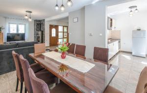 a dining room and living room with a table and chairs at Nice Home In Brestovac With Sauna in Novo Zvecevo