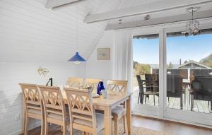 a dining room with a table and chairs and a balcony at 3 Bedroom Amazing Home In Kalundborg in Kalundborg