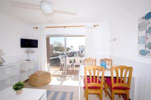 サン・フェリウ・デ・ギホルスにあるVista mar en S'Agaró a 100m de la playaのテーブルと椅子のあるキッチンとダイニングルーム