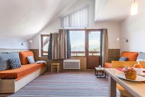 a living room with a couch and a table at Résidence Pierre & Vacances Le Britania in La Tania
