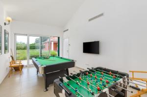 a living room with a pool table and a flat screen tv at Villa Village by Villsy - with heated pool, spa, private tennis court, golf court, basketball court and playroom in Tinjan