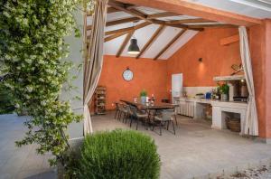 an outdoor patio with a table and a kitchen at Villa Village by Villsy - with heated pool, spa, private tennis court, golf court, basketball court and playroom in Tinjan