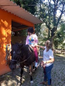 a woman petting a little girl on a horse at Casa da Avó Maria na Quinta do Castro in Manhuncelos
