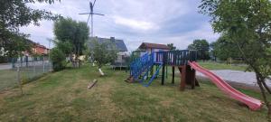 a playground with a slide and a wind turbine at Agro domki u Kasi in Kazimierz