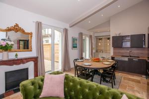 a living room with a green couch and a table at Les Tropeziennes de Libourne in Libourne