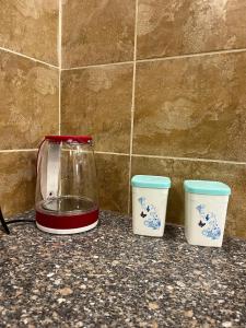 three cups on a counter next to a blender at Uptown urban apartment in Jerash