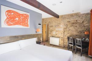 a bedroom with a bed and a desk in a room at Hotel Alda Algalia in Santiago de Compostela