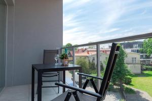 a balcony with a table and a view of a yard at VacationClub - Moon Residence Apartament 12 in Ustronie Morskie