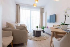a living room with a couch and a table at VacationClub - Moon Residence Apartament 12 in Ustronie Morskie