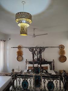 a room with a bed and a chandelier at Diani Beach Cottage Apartment in Ukunda +12 photos