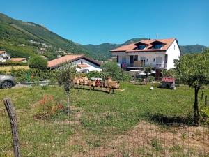 una casa in un campo con recinzione e alberi di The Cottage ad Agerola