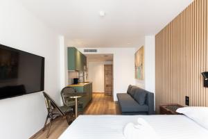 Una habitación de hotel con una cama y una sala de estar. en Les Suites HCR, en París
