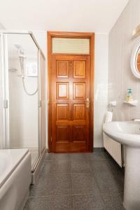 a bathroom with a wooden door and a sink at AVALON HOUSE in Galway +37 photos