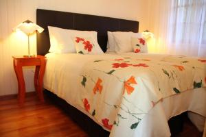 a bed with a white comforter with flowers on it at La Linda Cabañas in Dos de Mayo