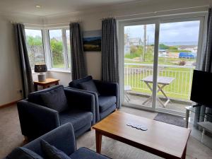a living room with a couch and chairs and a window at Trevose Golf and Country Club in Padstow
