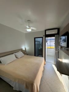 a bedroom with a large bed and a television at Pousada Mares do Sul - 100 metros do Embarque Ilha do Mel in Pontal do Paraná