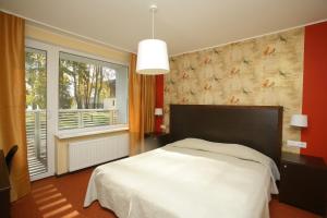 a bedroom with a white bed and a large window at Pühajärve Spa & Holiday Resort in Otepää
