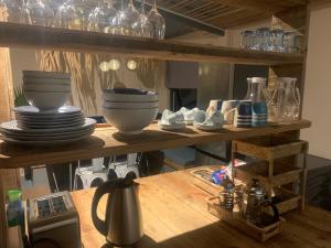 a kitchen shelf with plates and bowls on it at The Voyager lodge in Port Mathurin