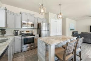 a kitchen with white cabinets and a kitchen island with chairs at 30A Pet Friendly Beach House - Beach Bayou by Panhandle Getaways in Santa Rosa Beach