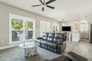 a living room with a leather couch and a table at 30A Pet Friendly Beach House - Beach Bayou by Panhandle Getaways in Santa Rosa Beach