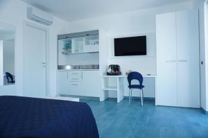a bedroom with a bed and a desk with a television at Casa del Mare Rooms & Apartments in Marina di Camerota