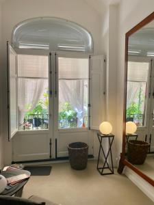 a living room with two large windows and a mirror at Casa 3D'Oro Palermo in Palermo