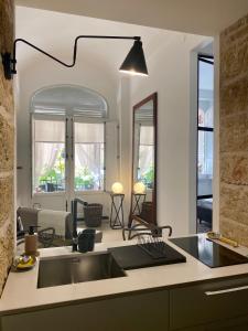 a kitchen with a sink and a living room at Casa 3D'Oro Palermo in Palermo