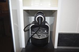 a black appliance sitting in a white cabinet at Appartement Sélestat in Sélestat