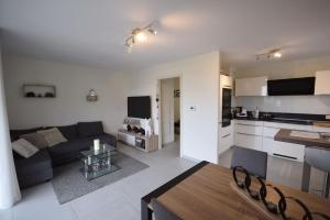 a living room and kitchen with a couch and a table at Appartement Sélestat in Sélestat