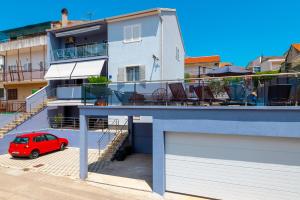 a red car parked in front of a house at Pool apartman Maja in Šibenik