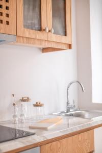 a kitchen with a sink and wooden cabinets at Kosi Suites in Corfu Town +33 photos