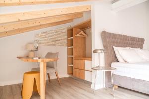 a bedroom with a bed and a table and a desk at Kosi Suites in Corfu Town
