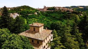 a building on the side of a hill with trees at Villa Cà Paciotti dal 1500 - Urbino e Rinascimento! in Urbino