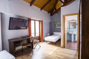 a room with a desk and a bedroom with a sink at Hotel Alda Algalia in Santiago de Compostela