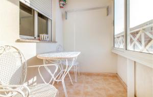 a small balcony with a table and chairs at Amazing Apartment In Torrevieja in Torrevieja +13 photos