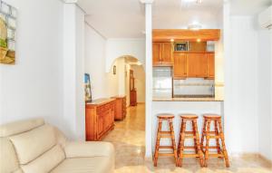 a kitchen with a couch and two bar stools at Amazing Apartment In Torrevieja in Torrevieja