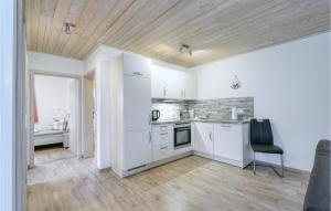 a kitchen with white cabinets and a black chair at Ferienhaus 12 Altefähr in Altefähr