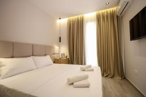 a bedroom with a white bed with two towels on it at Blue Studios by Comfort Suites in Golem