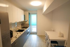 a kitchen with white cabinets and a table and a counter at Hunyadi Luxury Evolution in Sibiu