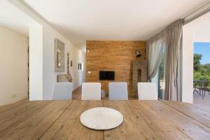 salon ze stołem i białymi krzesłami w obiekcie Villa Lisy by Perle di Puglia w mieście Carovigno