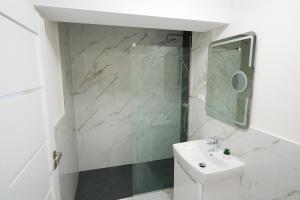 a white bathroom with a sink and a mirror at Hunyadi Luxury Evolution in Sibiu