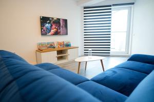a living room with a blue couch and a table at Hunyadi Luxury Evolution in Sibiu