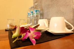 un tavolo con due tazze e fiori sopra di The Meeting House Aonang - self service ad Aonang Beach