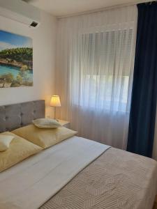 a bedroom with a large bed with a window at Palm Blues in Vodice +59 photos