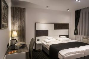 - une chambre avec un lit et un bureau dans l'établissement Log In Rooms, à Zagreb