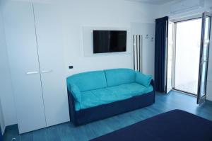 a blue couch in a living room with a tv at Casa del Mare Rooms & Apartments in Marina di Camerota