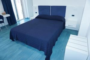 a bedroom with a blue bed and a white dresser at Casa del Mare Rooms & Apartments in Marina di Camerota