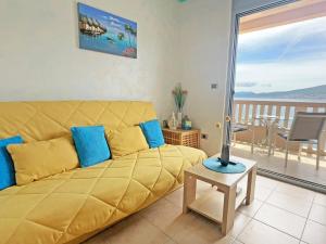 a living room with a yellow couch and a balcony at Vila Jadranka Apartments in Herceg-Novi